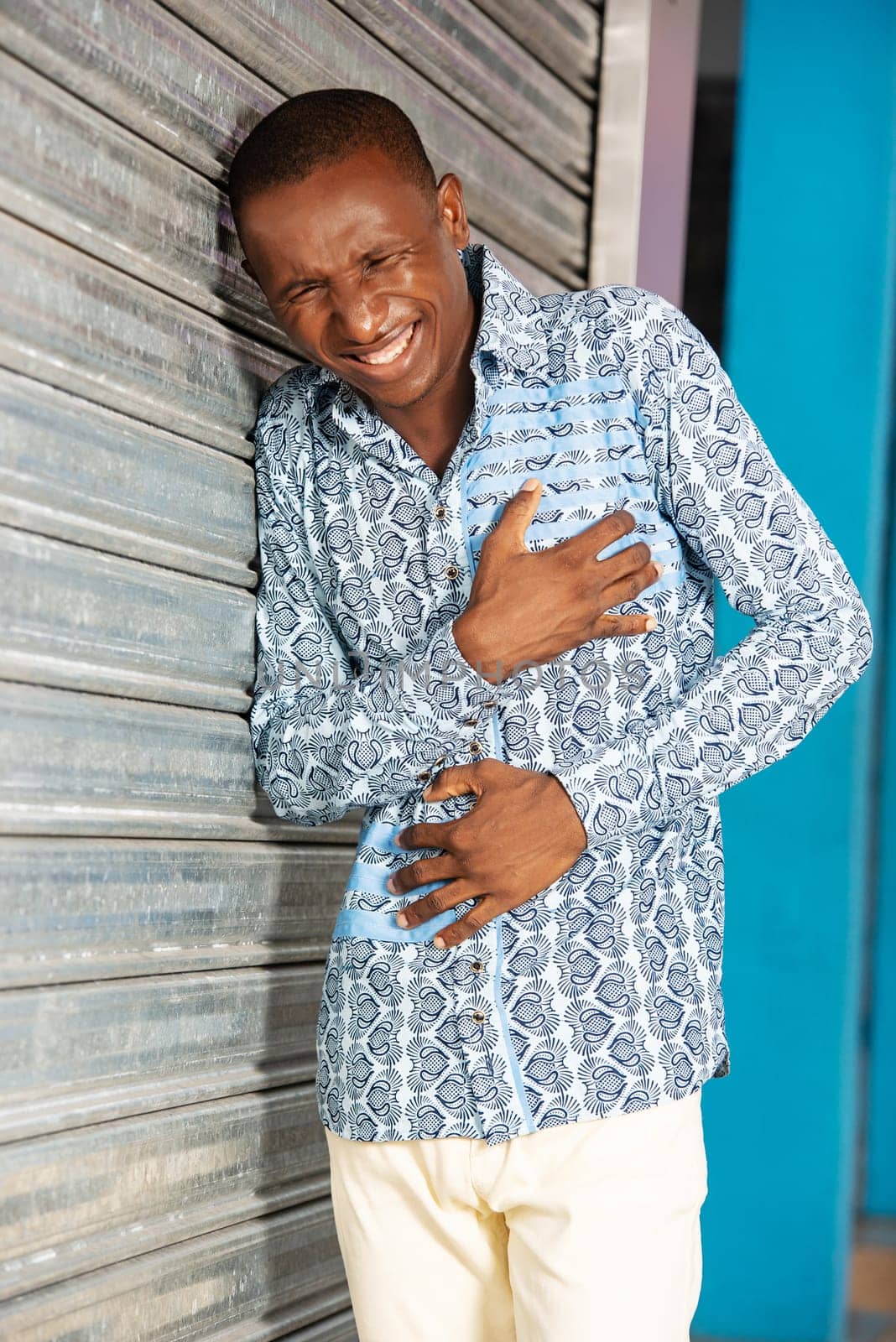 handsome adult businessman wearing shirt and jeans with hand on belly suffering from stomach pain and chest on the street