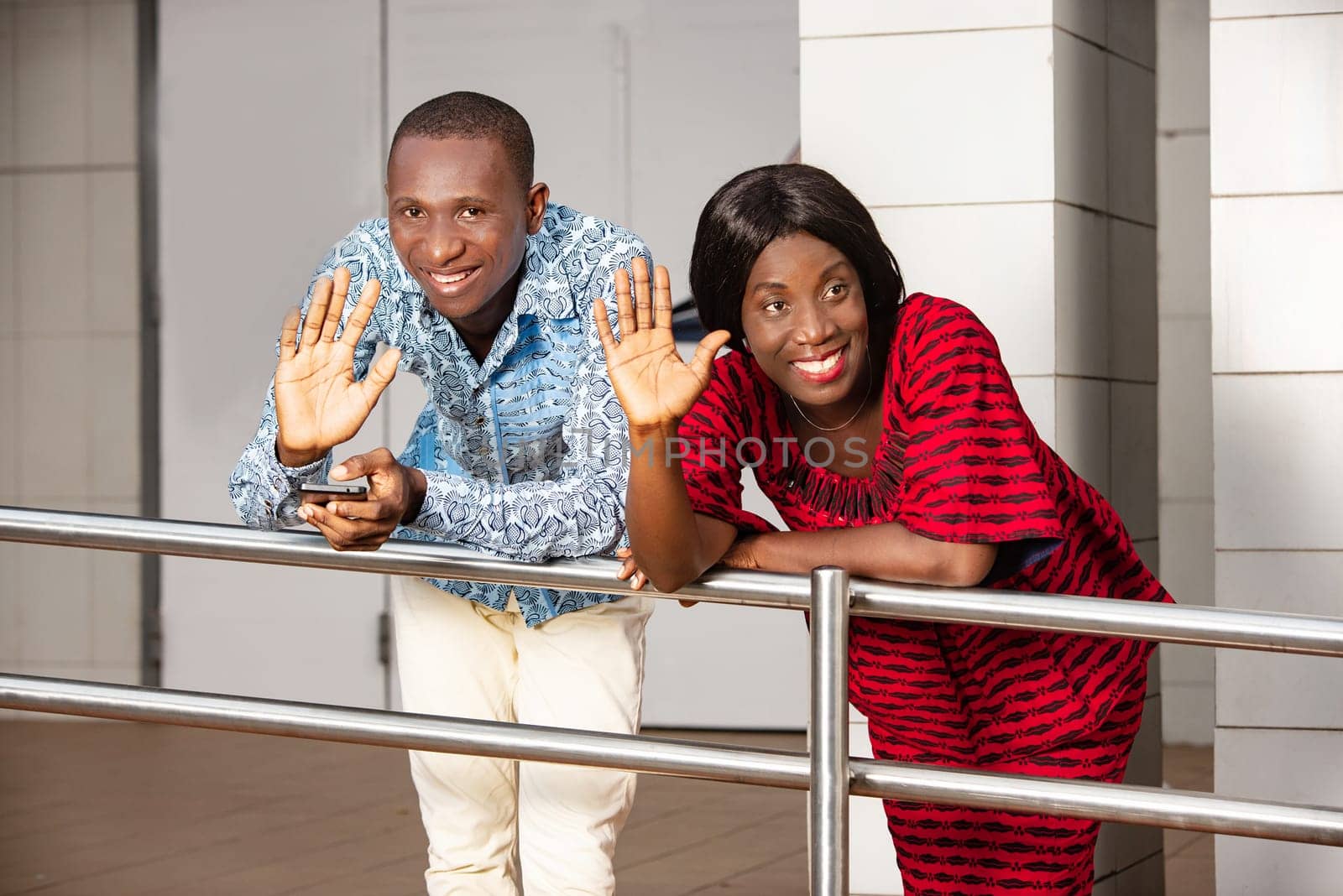 two business people in traditional clothes greeting someone with a smile.