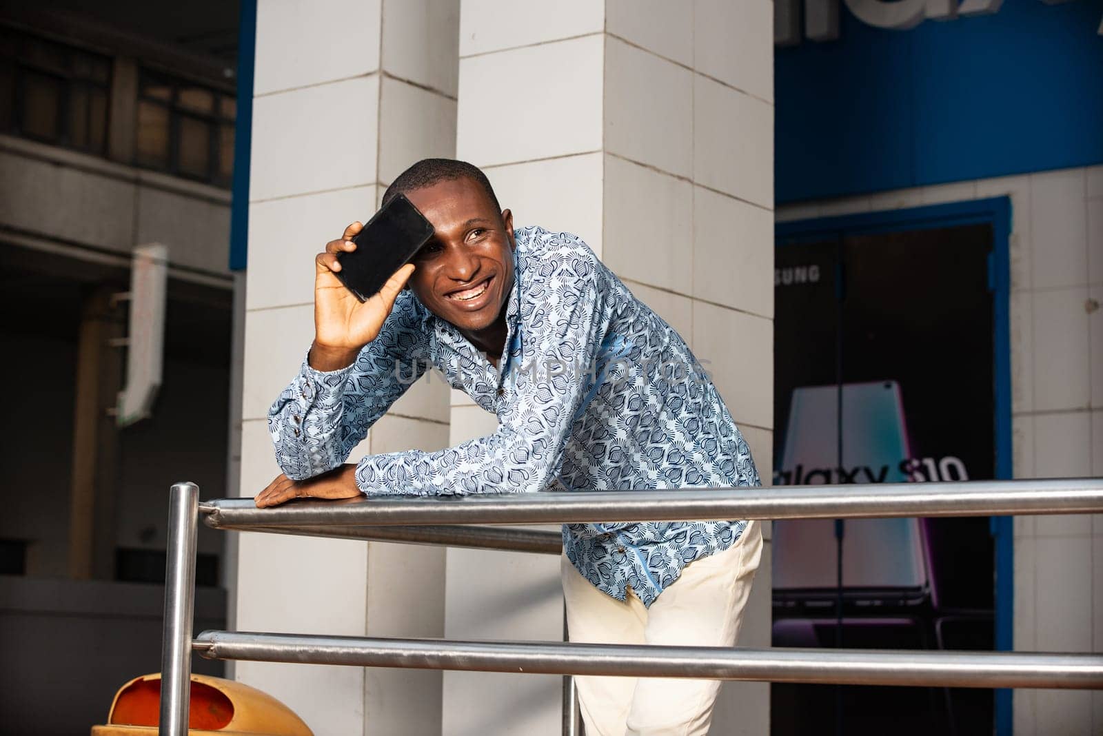 handsome adult african businessman using a mobile phone while being very happy