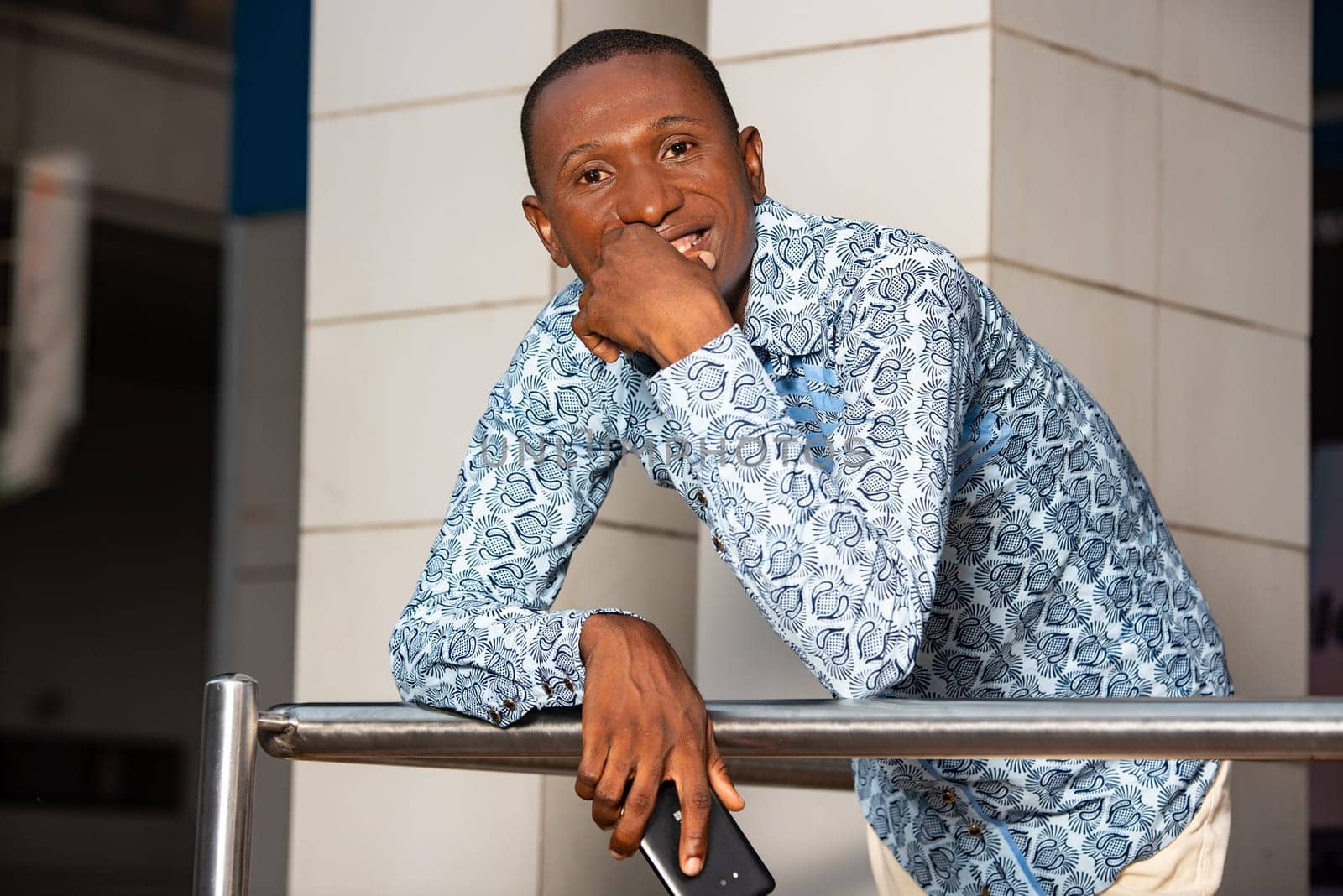 handsome adult african businessman using a mobile phone while being very happy