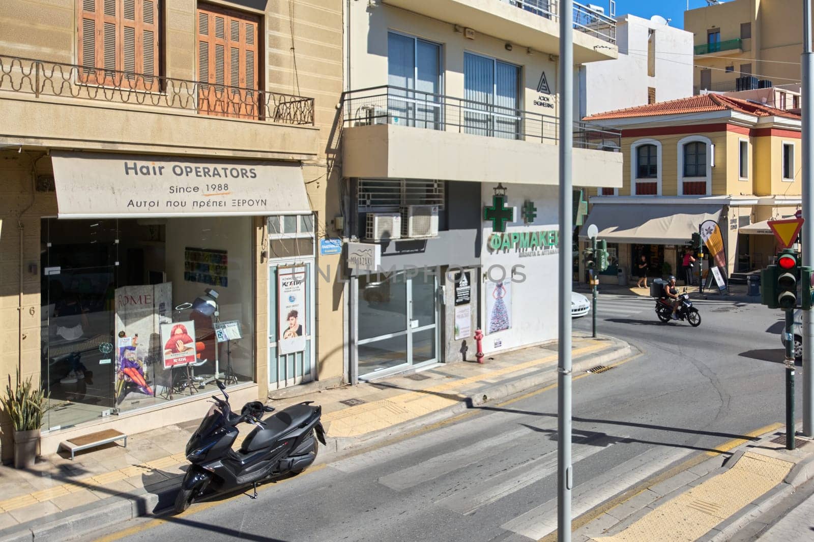 Crete.Greece - april 13, 2025: A charming pharmacy in Heraklion with a green cross symbol and Greek signage, blending traditional architecture with everyday urban life.