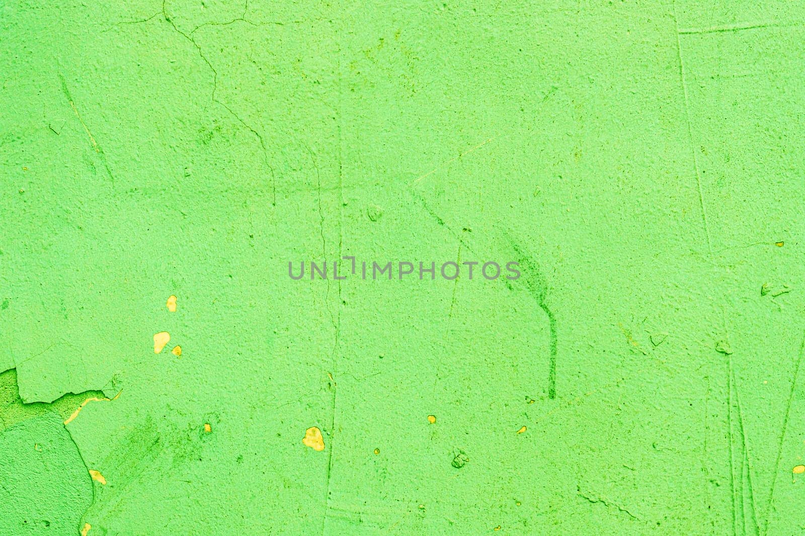 Abandoned, damaged green paint on a wall close-up.