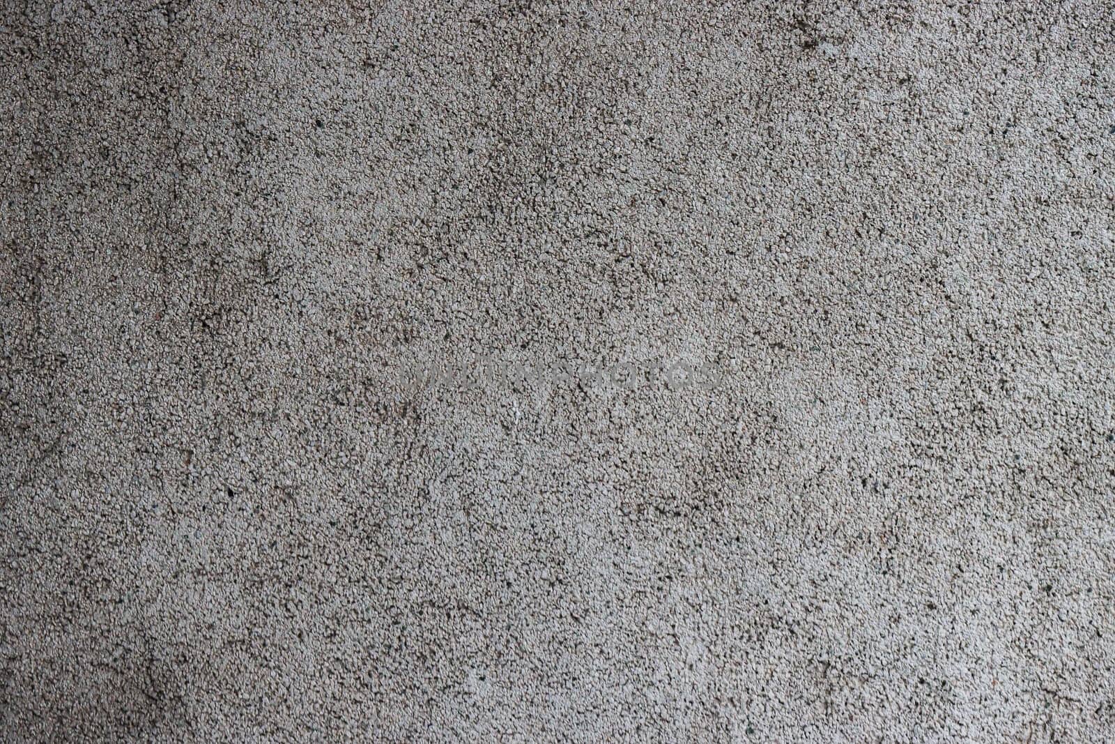 Close-up of a grey, rough concrete wall.