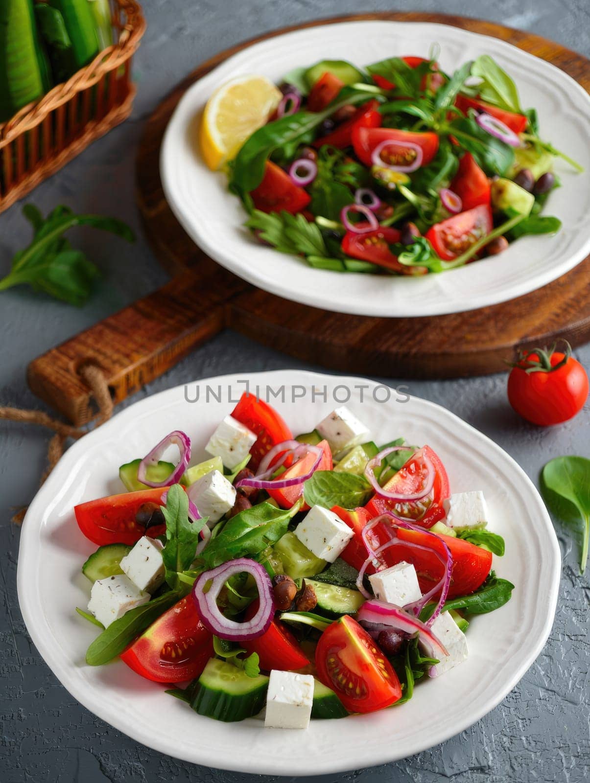 Two plates of fresh salad are presented.