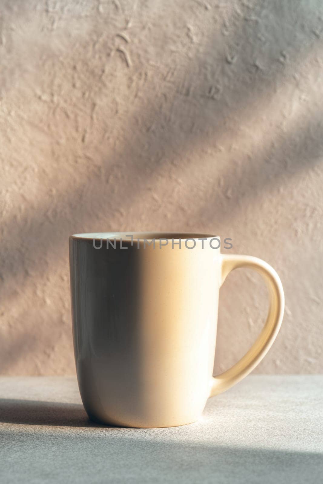 Elegant ceramic mug with soft natural shadows falling on a textured surface. Perfect for lifestyle mockups, branding projects, minimalist designs, or cozy morning-themed visuals.