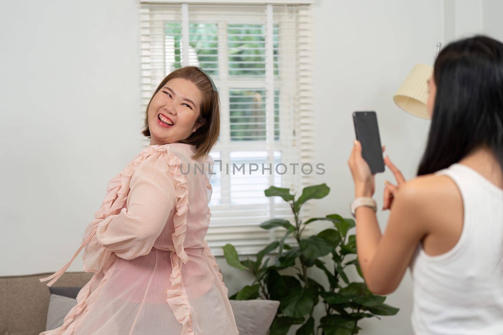 A cheerful woman poses for a photo during a beauty session, exemplifying fun and friendship in a light-hearted environment filled with beauty products.