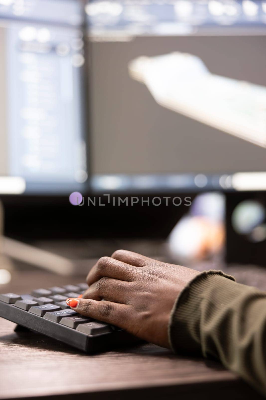 Closeup of african american person typing, inputting data into computer, improving geometry of digital machinery tool. Selective focus of black individual using keyboard and working on a cad software.