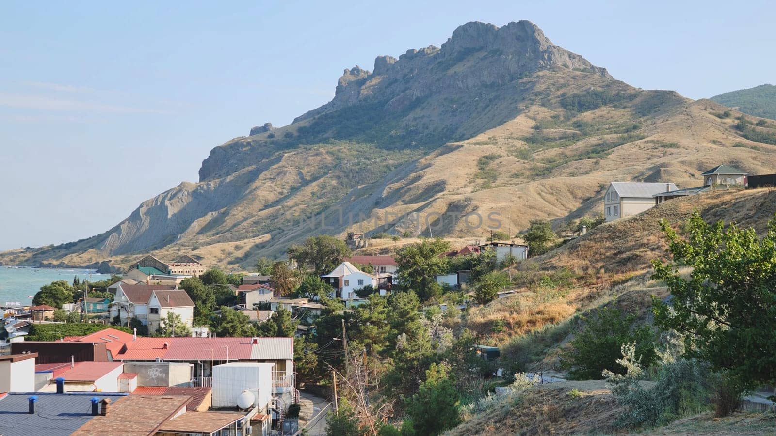 Charming coastal town of ordzhonikidze in crimea, nestled against the black sea, features a majestic mountain in the backdrop