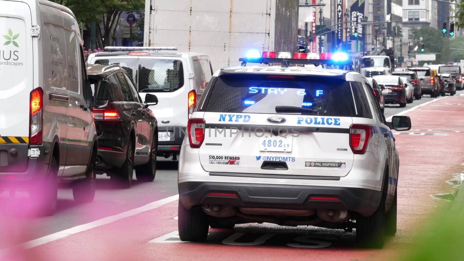 New York City, United States - 29 Aug 2023: Police patrol car, USA NYPD 911 vehicle, Manhattan Midtown, busy 34th street. American cop auto siren on avenue, urban traffic scene, Herald square in NYC.