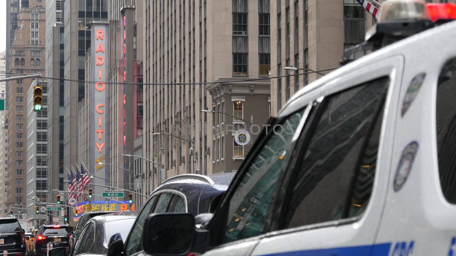 New York, United States - 10 Sept 2023: Police patrol car, Radio City Music Hall. USA NYPD 911 vehicle on Manhattan Midtown street. American cop auto siren light on 6 avenue. Urban traffic, road scene