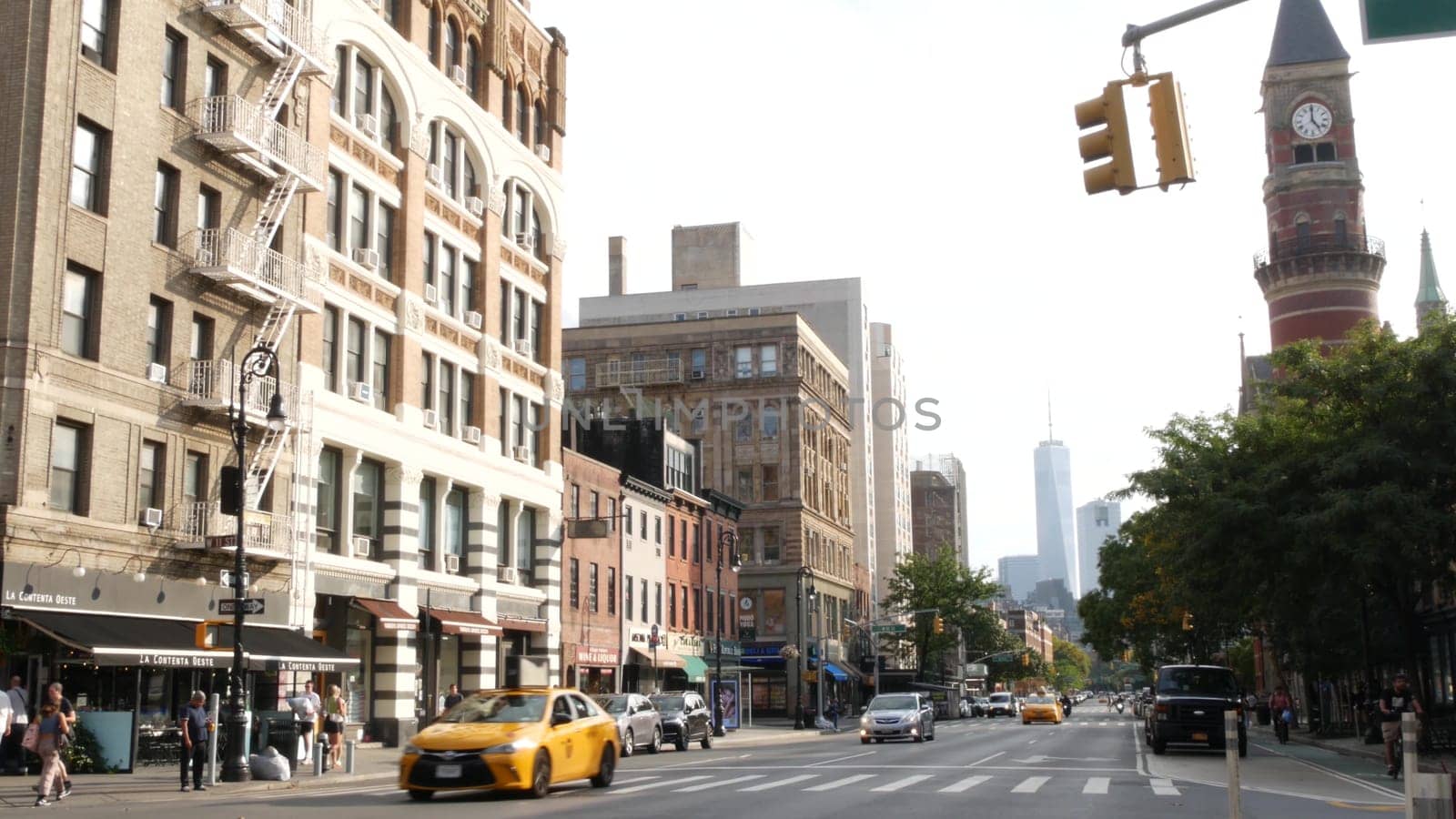 New York City, United States - 10 Sept 2023: Manhattan Greenwich Village street, Sixth 6 Americas avenue crossroad. Road traffic, yellow taxi. People, USA World trade center. Jefferson Market Library.