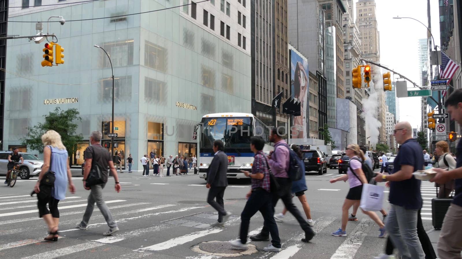 New York City, United States - 11 Sept 2023: Manhattan Midtown street, Fifth 5 avenue, USA. American urban Road traffic, crossroad intersection. People pedestrians on zebra crosswalk. Shopping store.