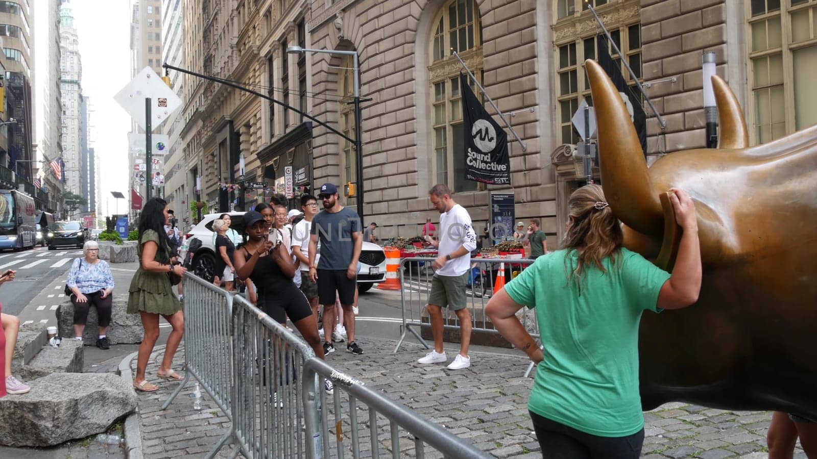 New York City, United States - 9 Sept 2023: Charging Bull, Wall street Stock Exchange symbol in USA. Lower Manhattan Downtown Financial District. American Broadway street. Tourist people photographing
