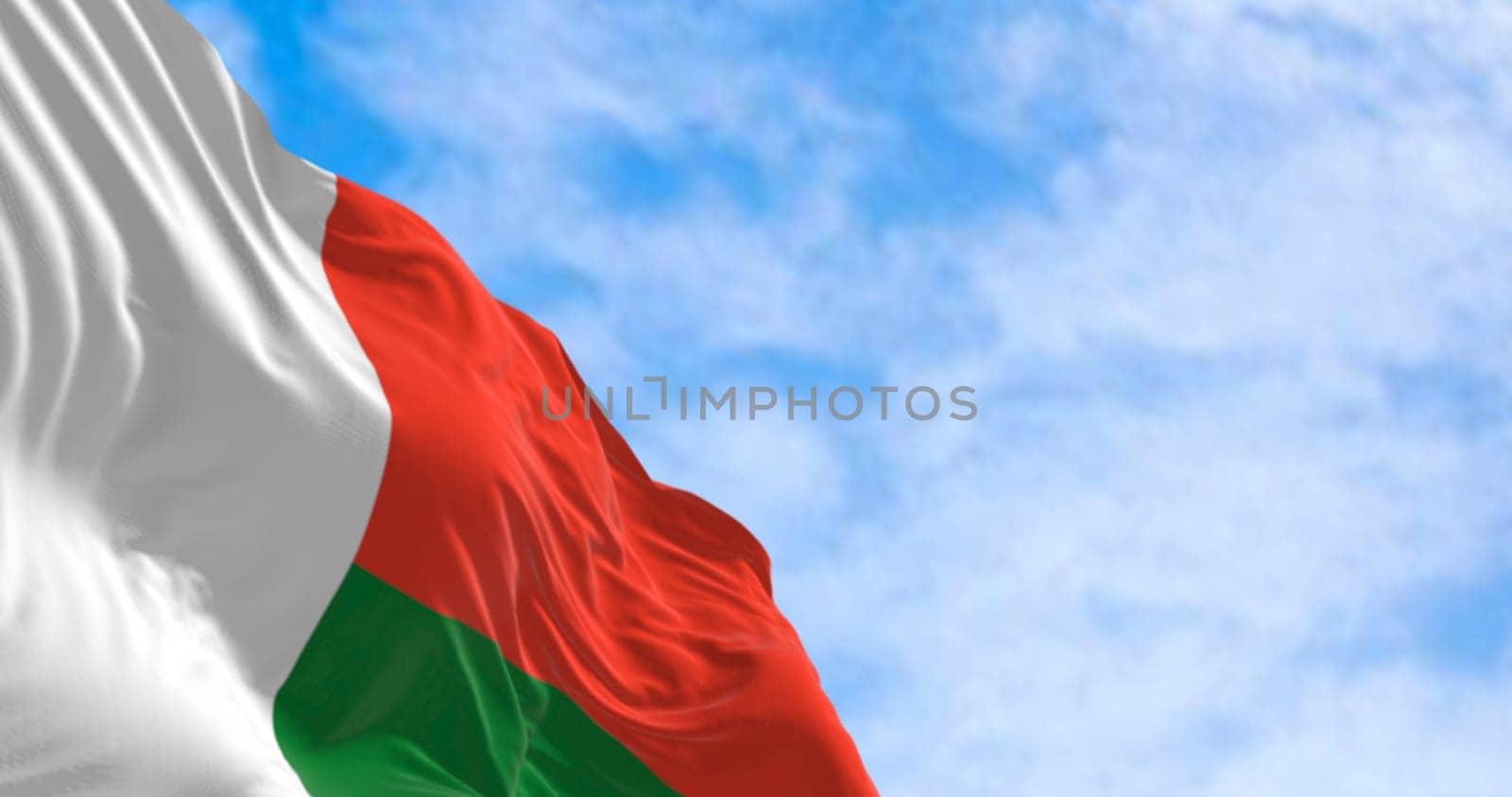 3D render of the national flag of Madagascar fluttering in the wind, symbolizing pride, independence, and African identity under a bright sky.
