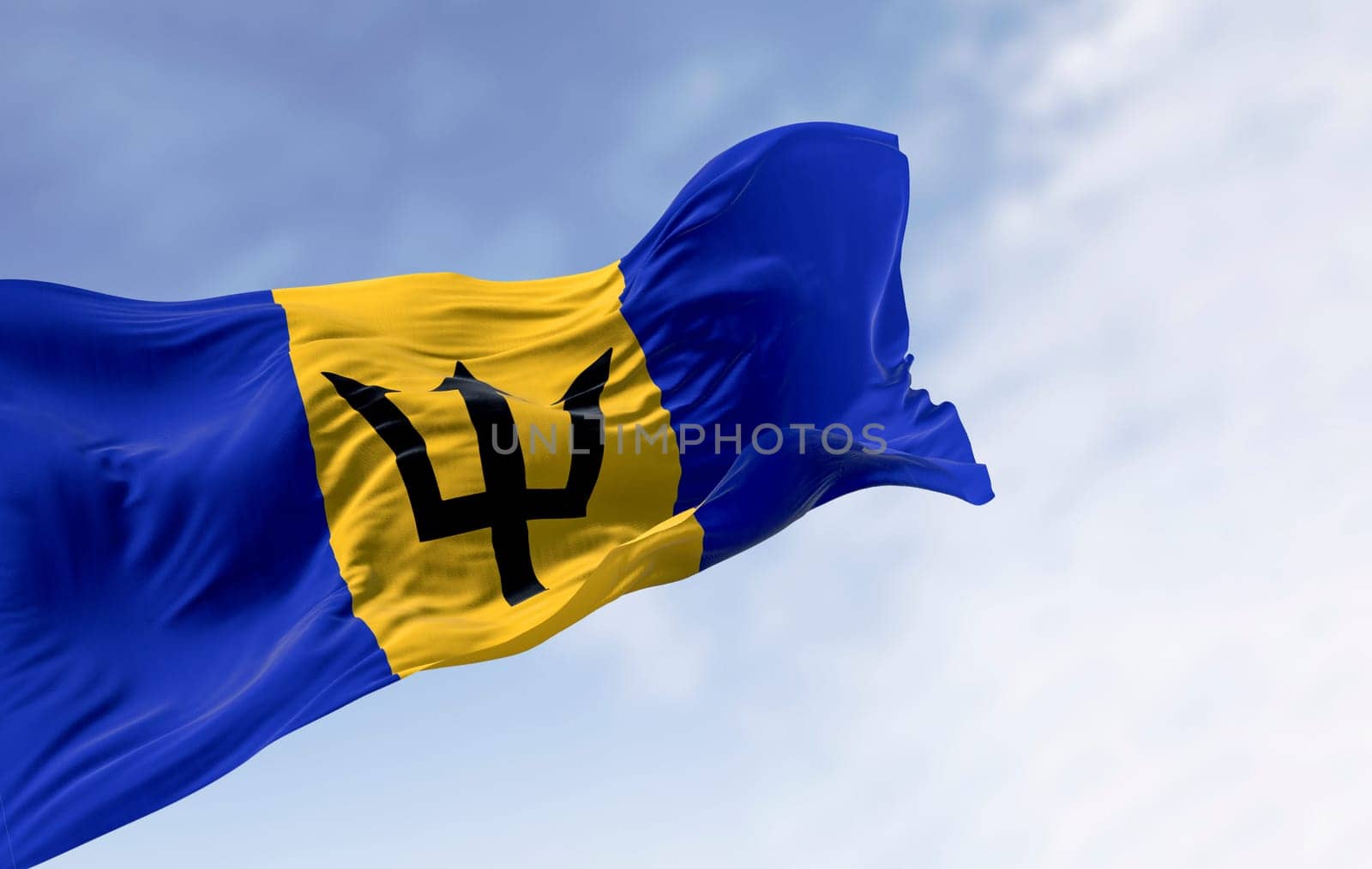 3D render of Barbados flag with the Broken Trident, a national symbol of pride, independence, and Caribbean identity. Blue sky and realistic fabric motion.