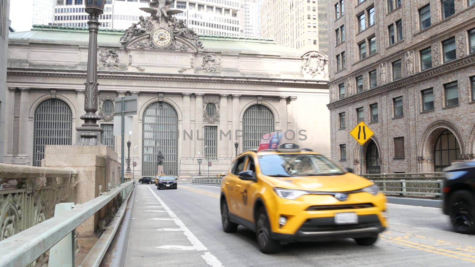 New York City, United States - 4 Sept 2023: Grand Central Terminal railway station building, 42 street. Manhattan Midtown. Yellow taxi cab, car transport on bridge, USA. American urban road traffic.