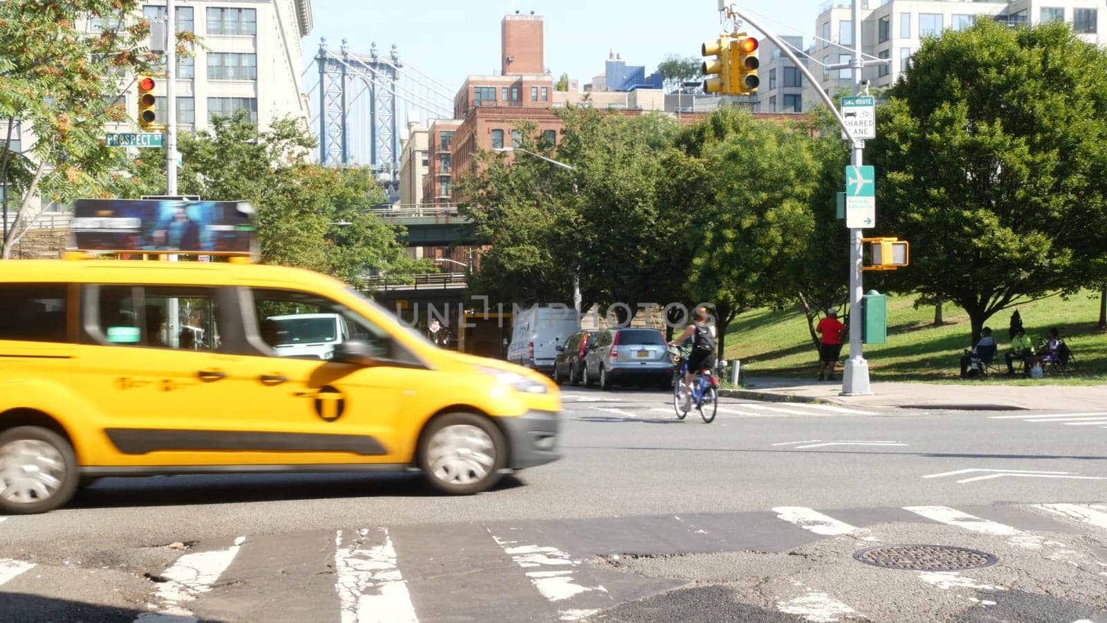 New York City, United States - 7 Sept 2023: Manhattan Bridge, Brooklyn Dumbo. Cars on road, traffic on Washington street crossroad. NYC yellow taxi cab. People walking, pedestrians and zebra crosswalk