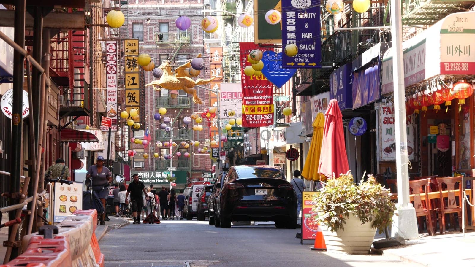 New York City, United States - 14 Sept 2023: Manhattan Chinatown Pell street. Chinese culture, ethnic district architecture, USA. Red brick buildings, round paper lanterns and hieroglyph signs. People