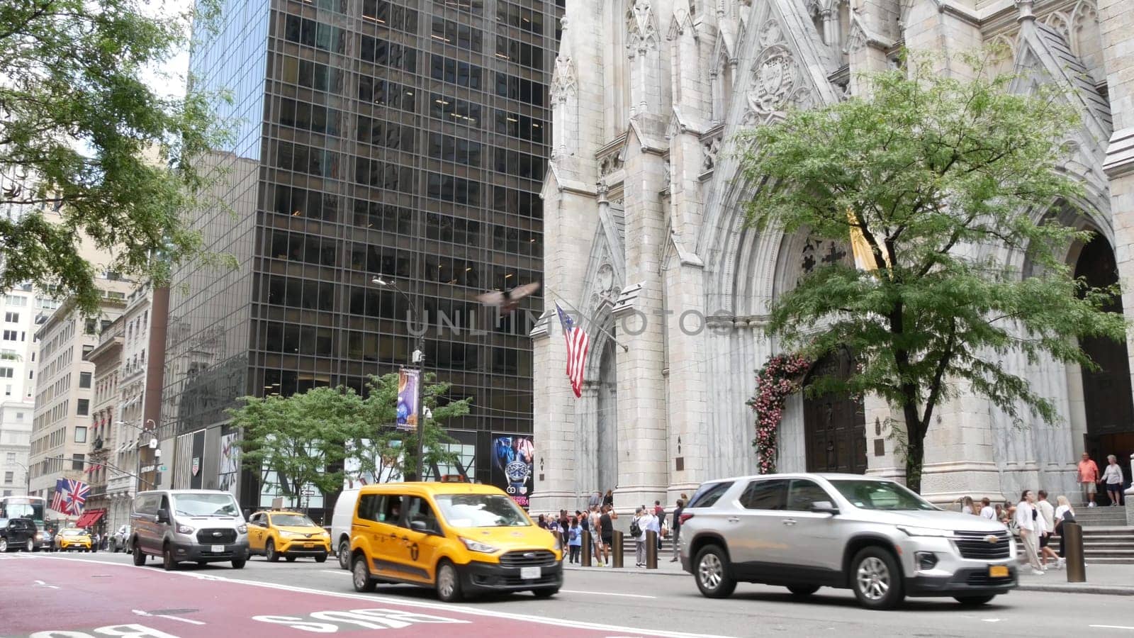 New York City, United States - 11 Sept 2023: Manhattan Midtown street, Fifth 5 avenue, 5th ave, American urban road car traffic, Yellow taxi cab in USA. Saint St Patricks Cathedral. People pedestrians