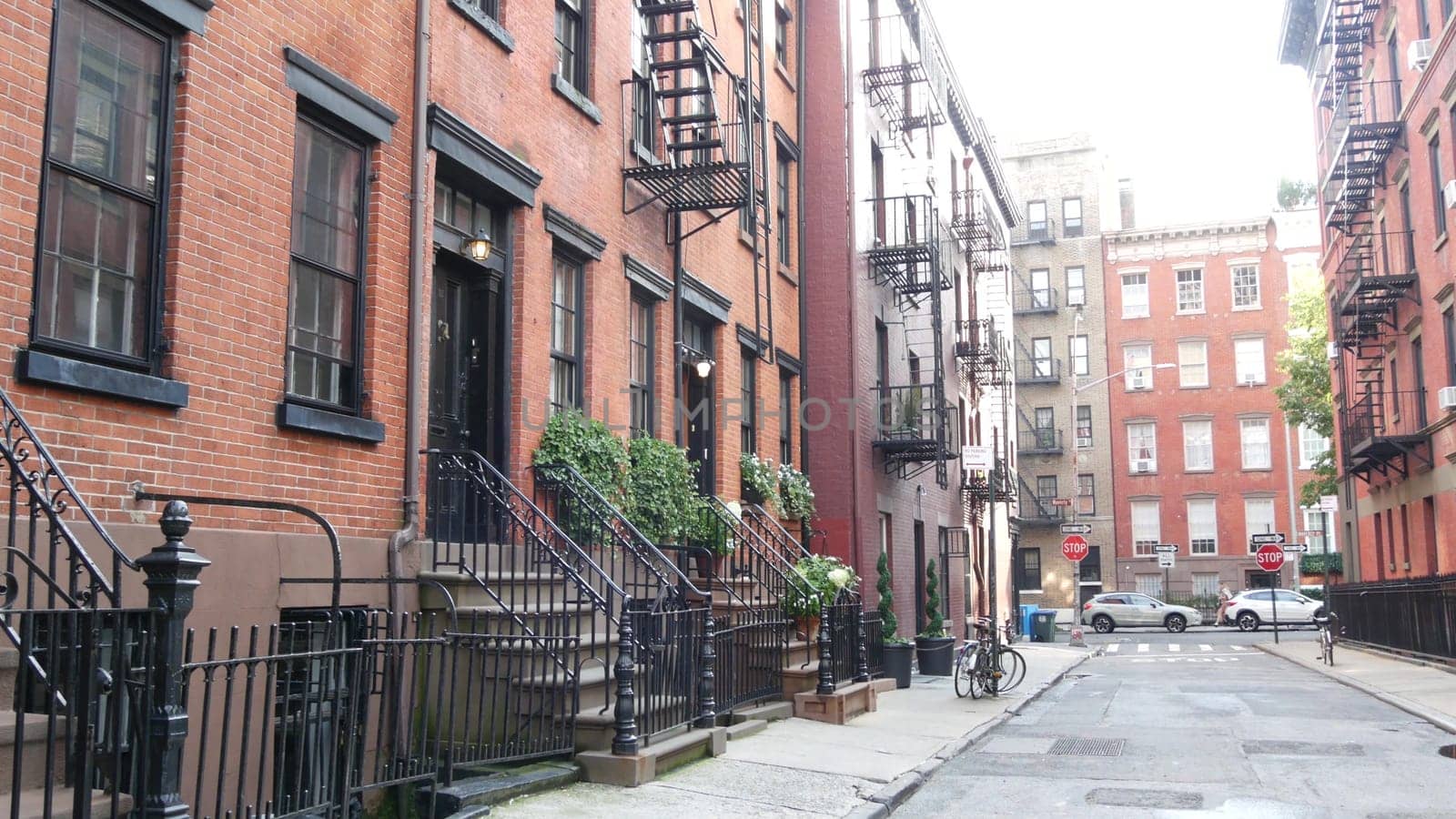New York City, United States - 10 Sept 2023: Building architecture. Urban residential house exterior. Real estate property, USA. Red brick facade. Greenwich Village Gay street. Fire escape ladder exit