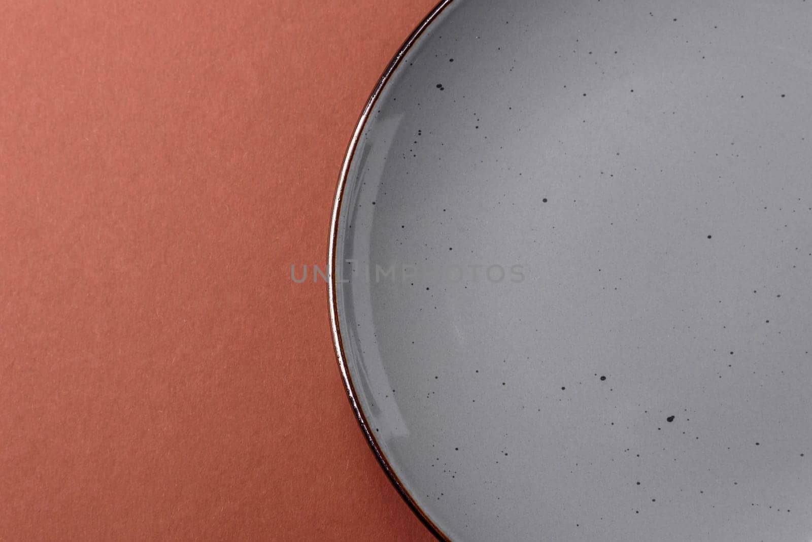 Empty ceramic plate on a monochrome brown background. Empty plate with cutlery on a dining table