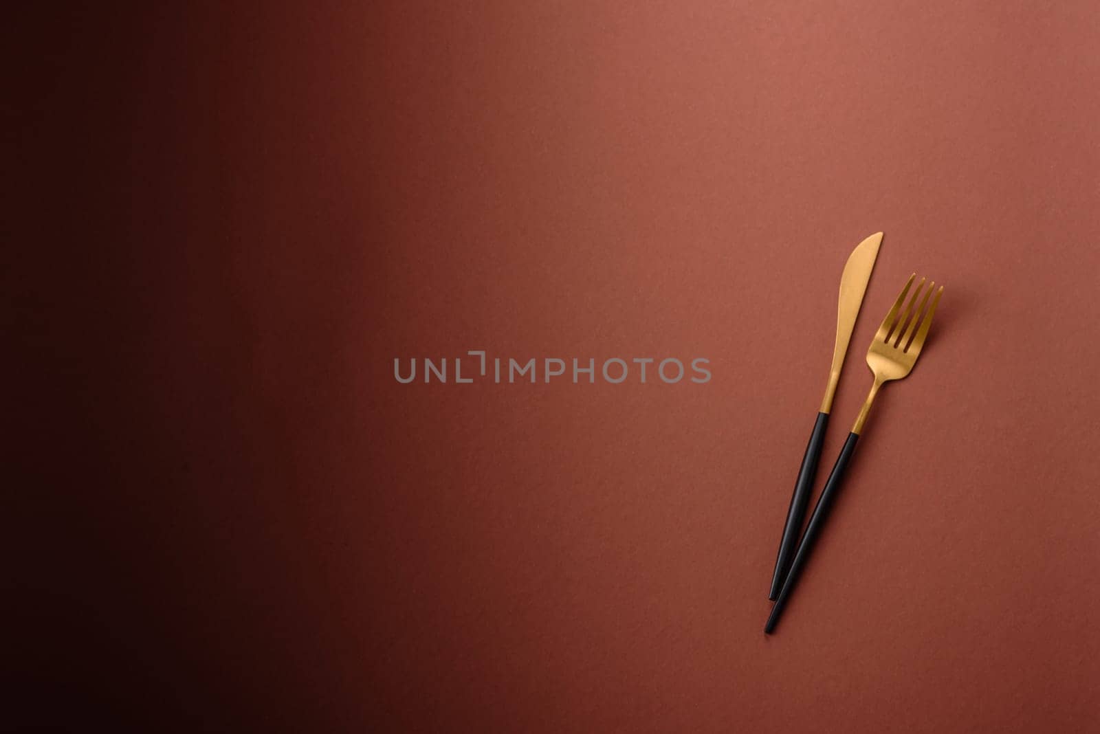 Knife and fork, cutlery on a brown dining table. Utensils and crockery for preparing dinner