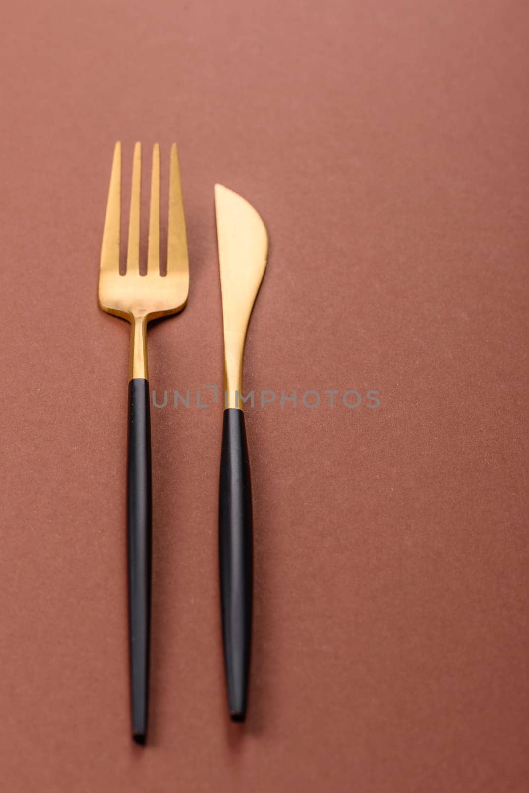 Knife and fork, cutlery on a brown dining table. Utensils and crockery for preparing dinner