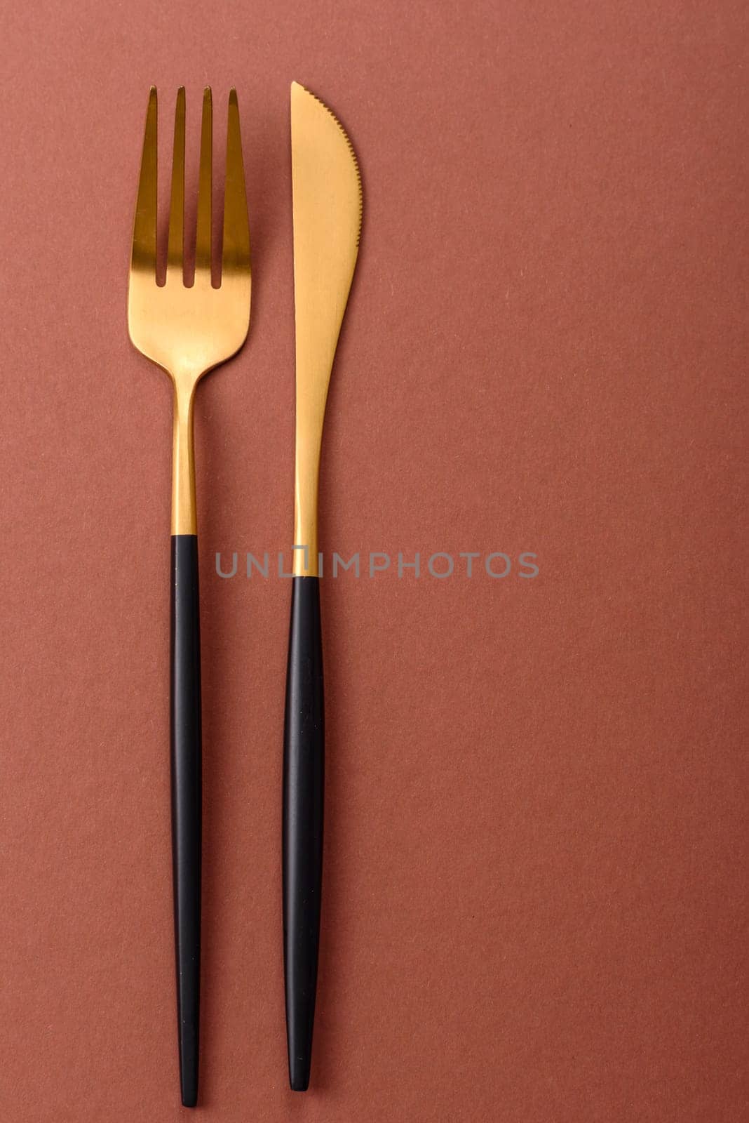 Knife and fork, cutlery on a brown dining table. Utensils and crockery for preparing dinner
