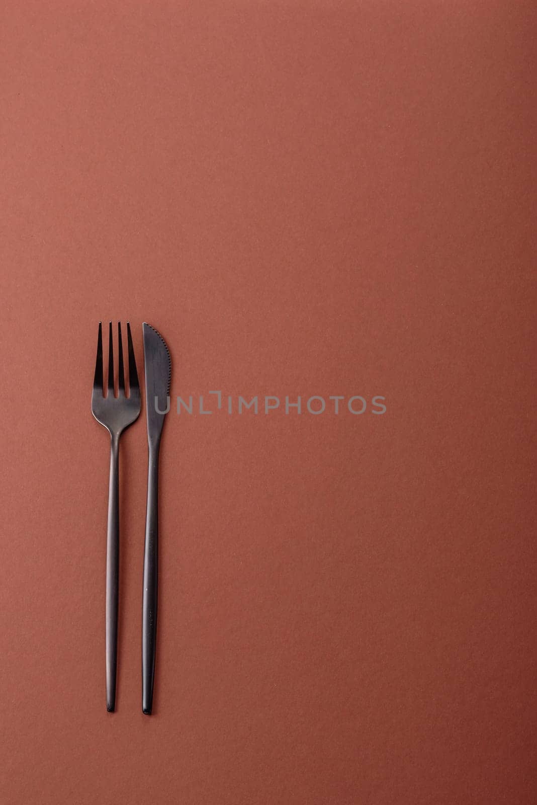 Knife and fork, cutlery on a brown dining table. Utensils and crockery for preparing dinner