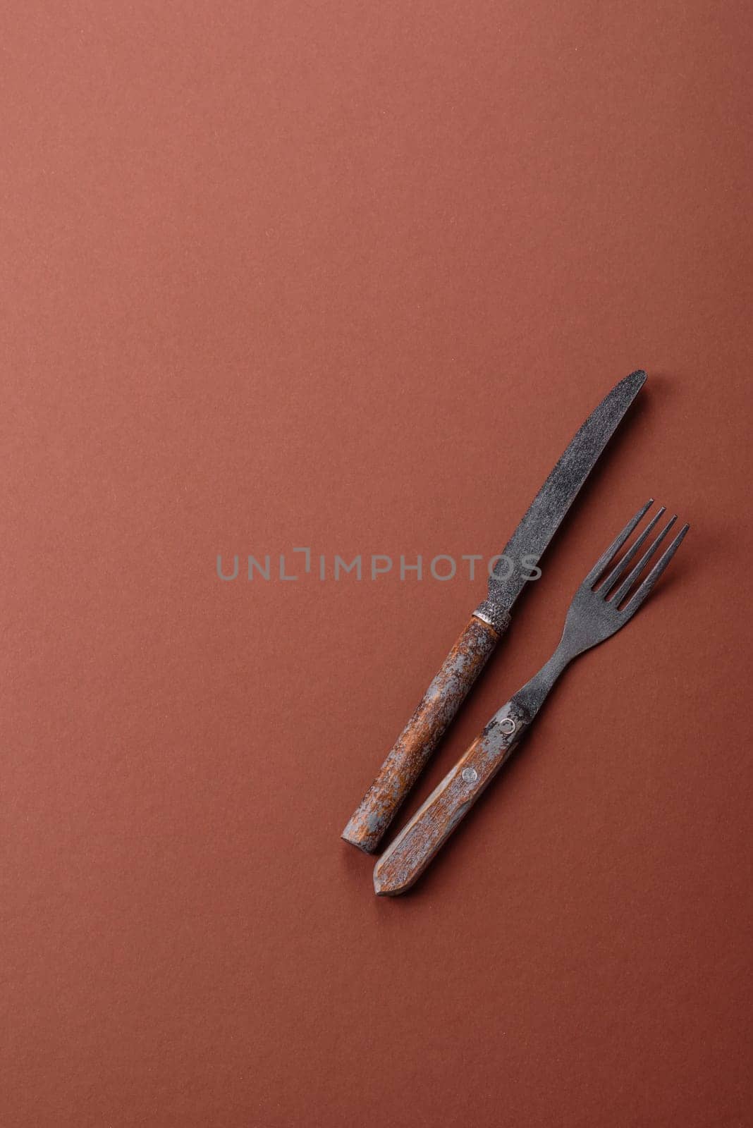 Knife and fork, cutlery on a brown dining table. Utensils and crockery for preparing dinner