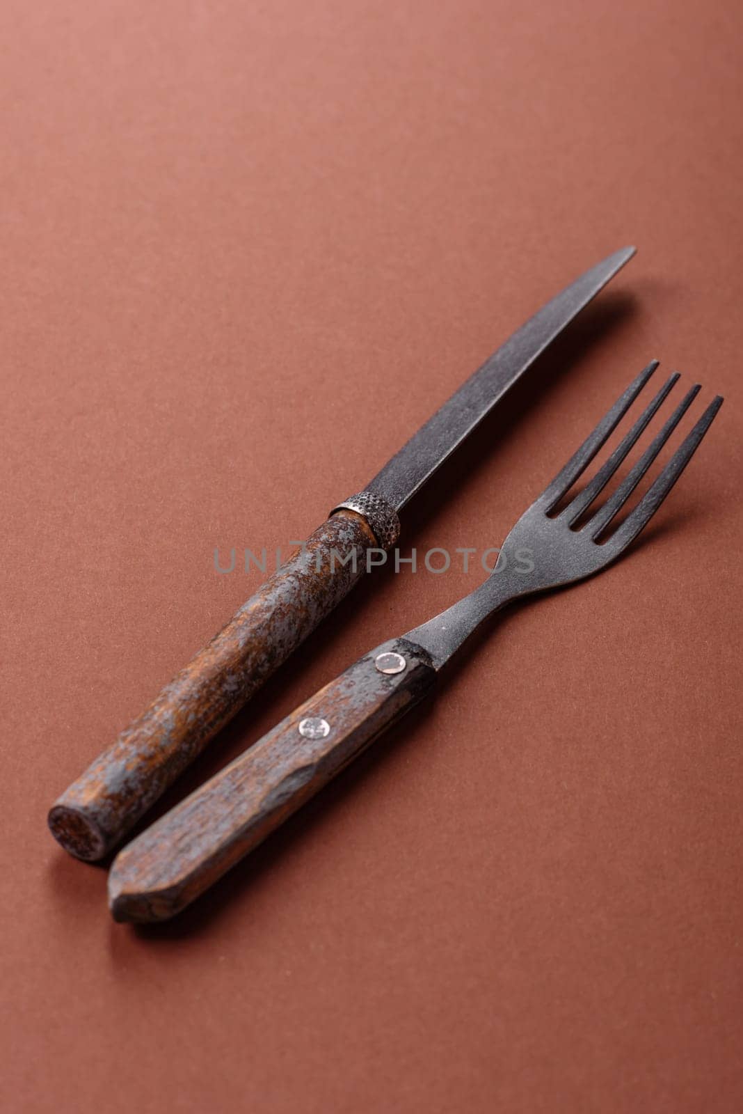 Knife and fork, cutlery on a brown dining table. Utensils and crockery for preparing dinner