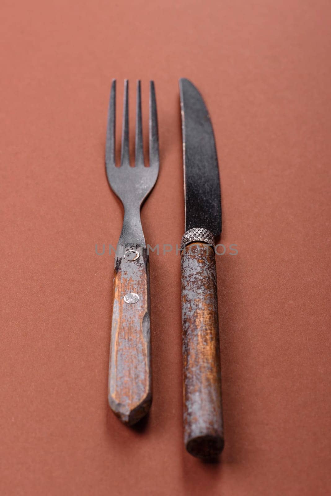 Knife and fork, cutlery on a brown dining table. Utensils and crockery for preparing dinner