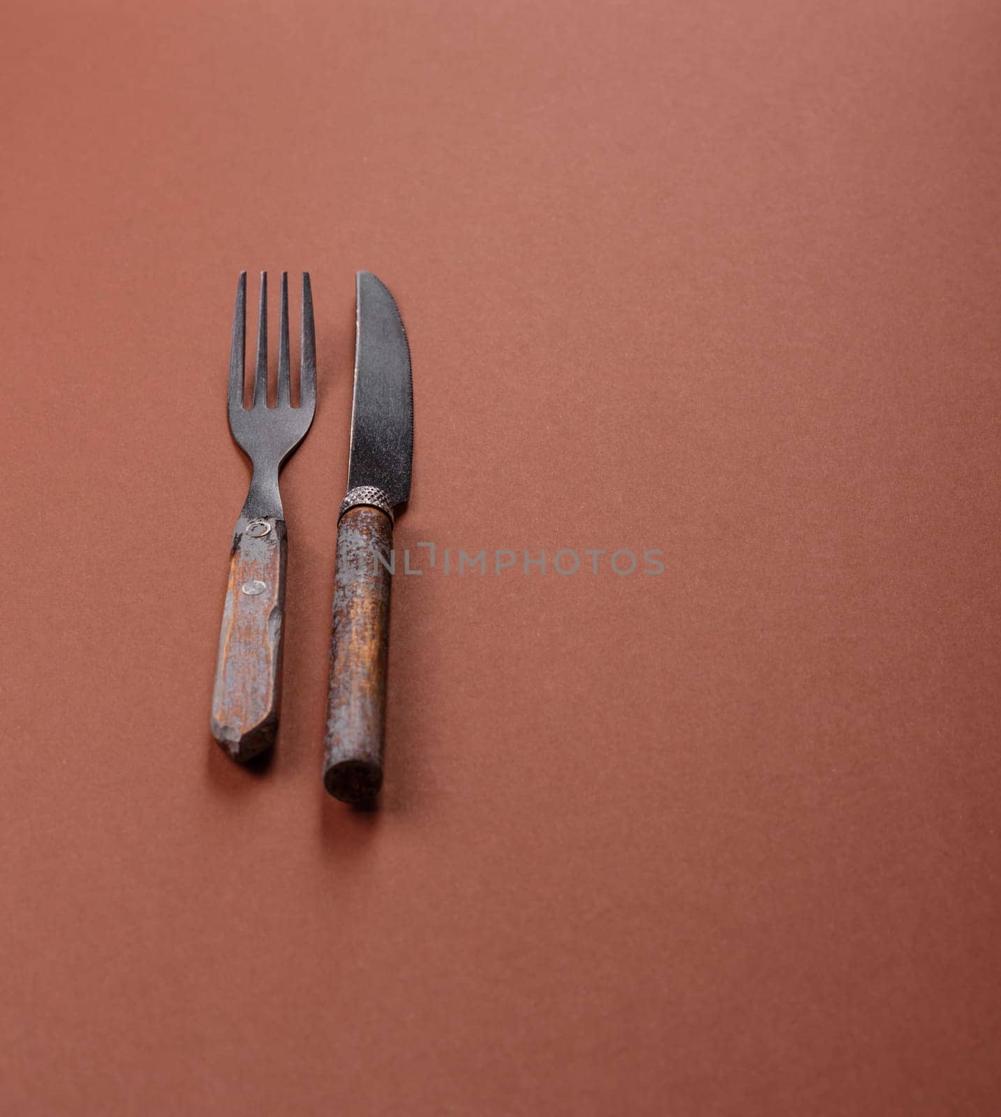 Knife and fork, cutlery on a brown dining table. Utensils and crockery for preparing dinner