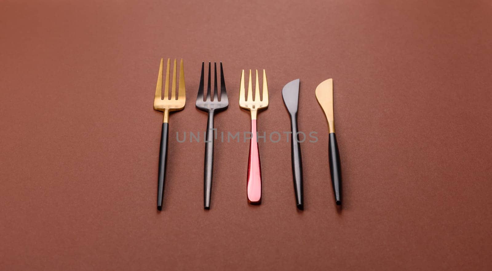 Knife and fork, cutlery on a brown dining table. Utensils and crockery for preparing dinner