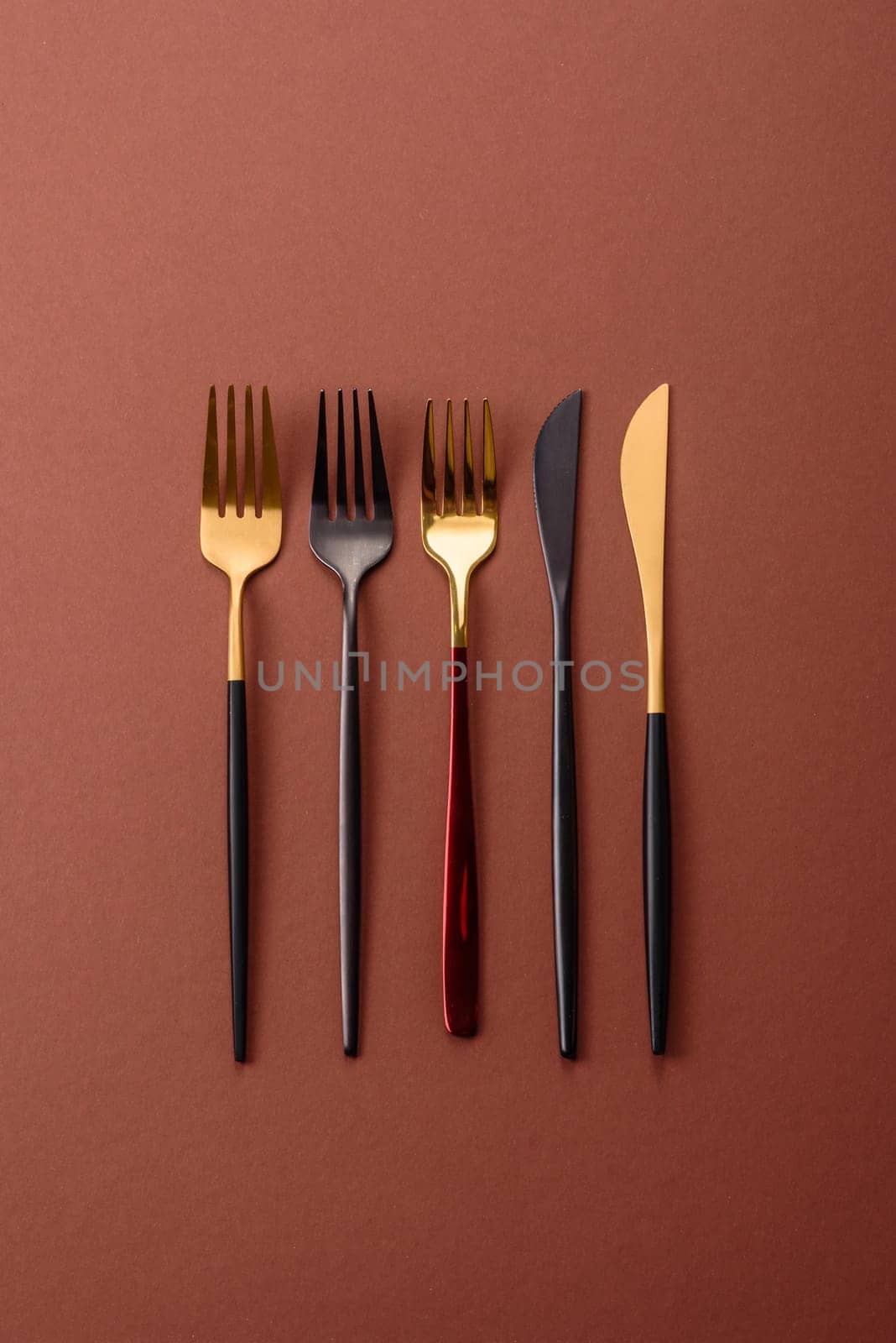 Knife and fork, cutlery on a brown dining table. Utensils and crockery for preparing dinner