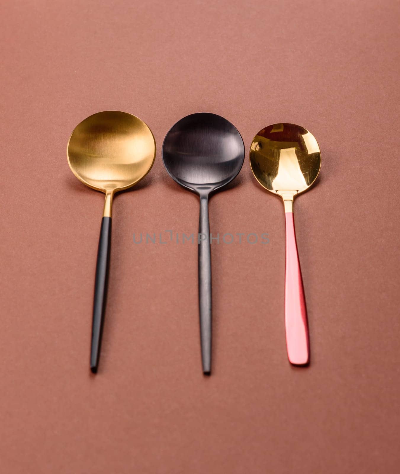 Empty metal spoon on a monochrome brown background. Cutlery on the dining table