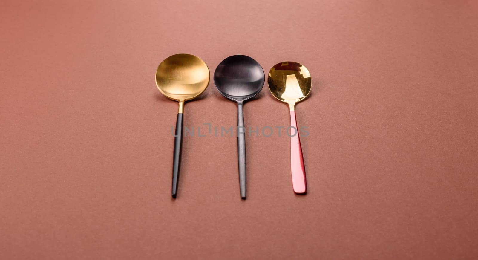 Empty metal spoon on a monochrome brown background. Cutlery on the dining table