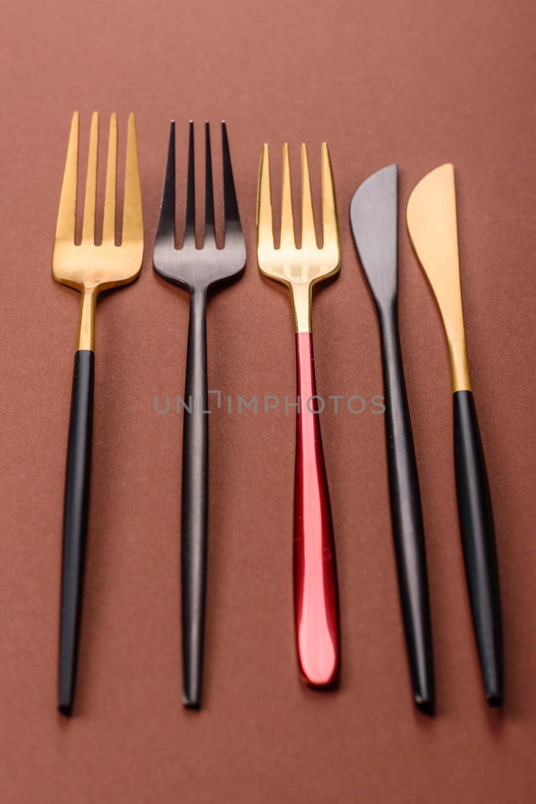 Knife and fork, cutlery on a brown dining table. Utensils and crockery for preparing dinner