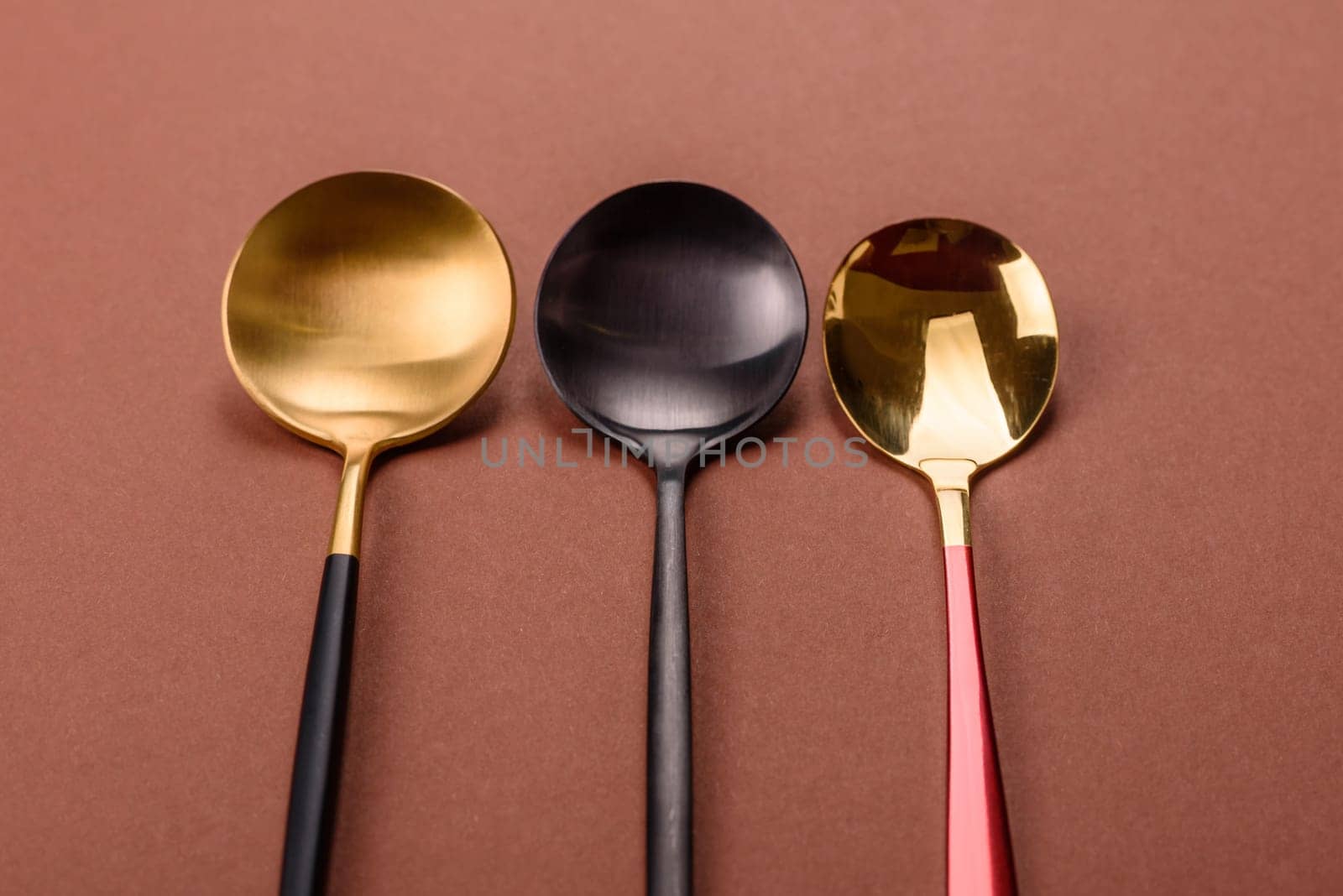 Empty metal spoon on a monochrome brown background. Cutlery on the dining table