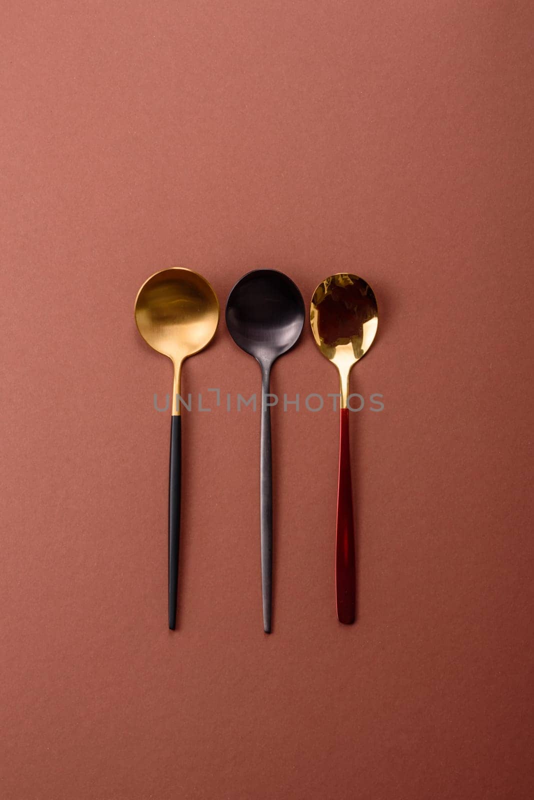 Empty metal spoon on a monochrome brown background. Cutlery on the dining table