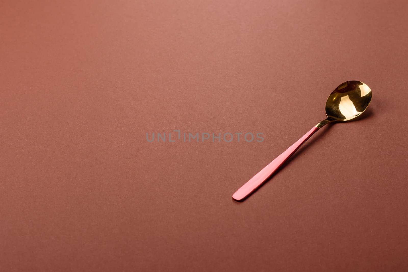 Empty metal spoon on a monochrome brown background. Cutlery on the dining table