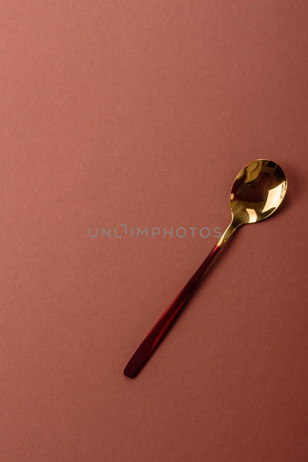 Empty metal spoon on a monochrome brown background. Cutlery on the dining table