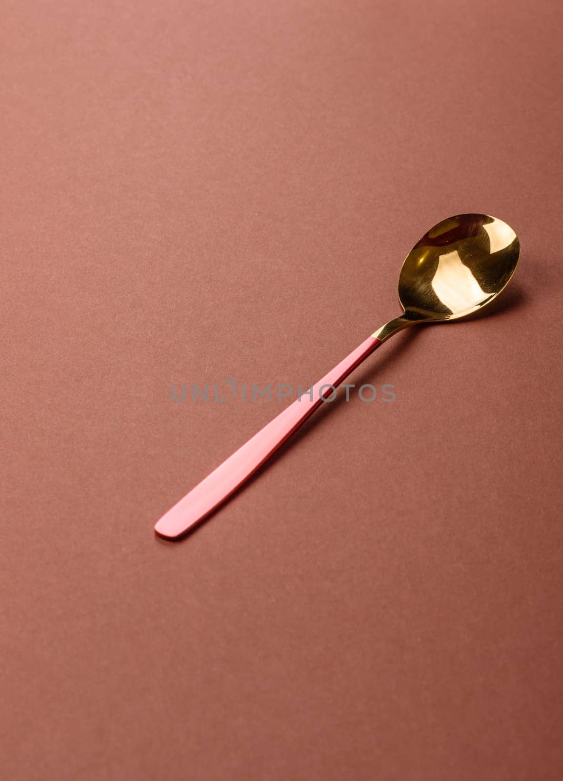 Empty metal spoon on a monochrome brown background. Cutlery on the dining table