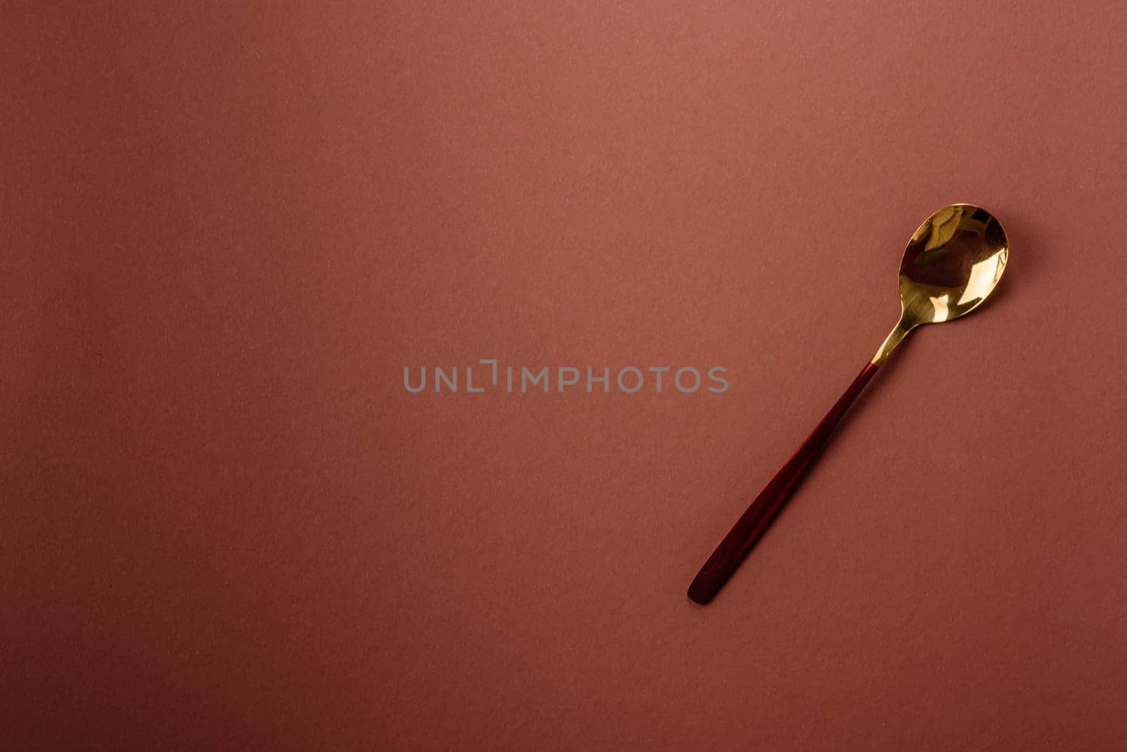 Empty metal spoon on a monochrome brown background. Cutlery on the dining table