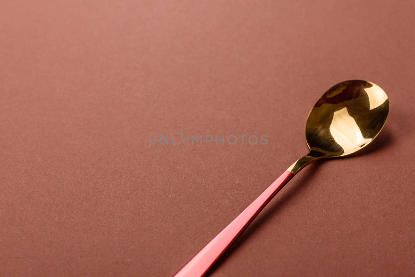 Empty metal spoon on a monochrome brown background. Cutlery on the dining table