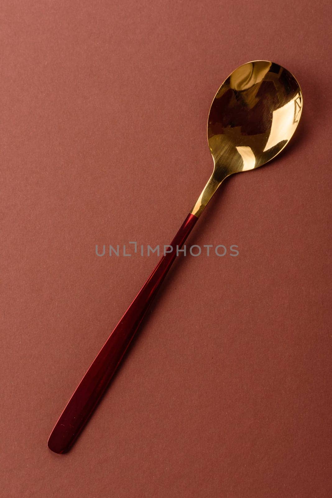 Empty metal spoon on a monochrome brown background. Cutlery on the dining table