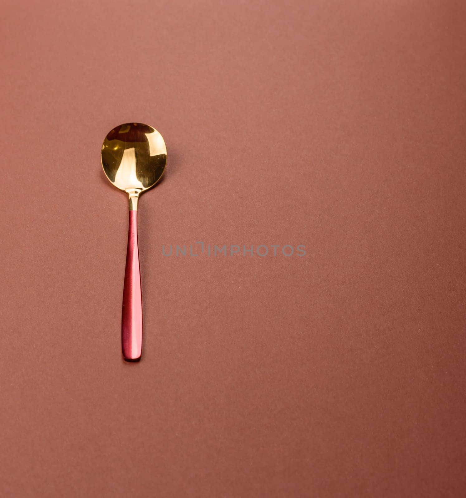Empty metal spoon on a monochrome brown background. Cutlery on the dining table
