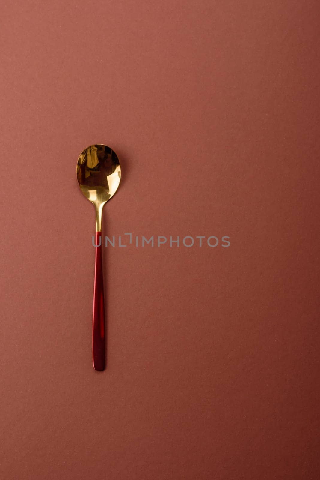 Empty metal spoon on a monochrome brown background. Cutlery on the dining table