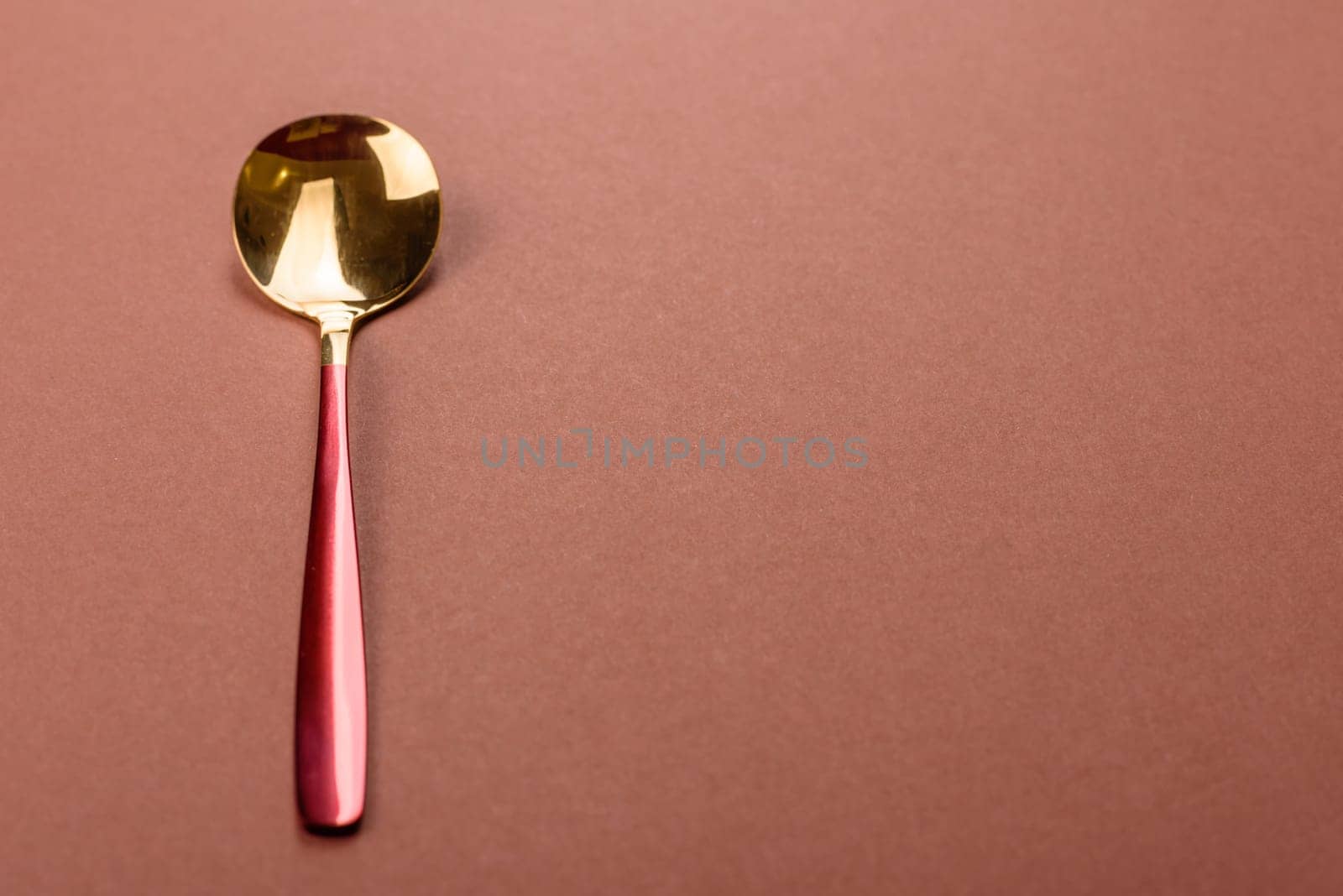 Empty metal spoon on a monochrome brown background. Cutlery on the dining table
