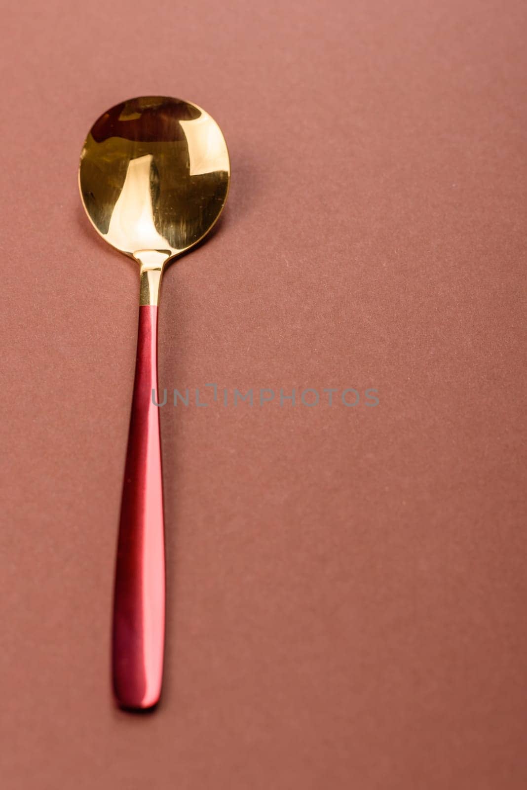 Empty metal spoon on a monochrome brown background. Cutlery on the dining table